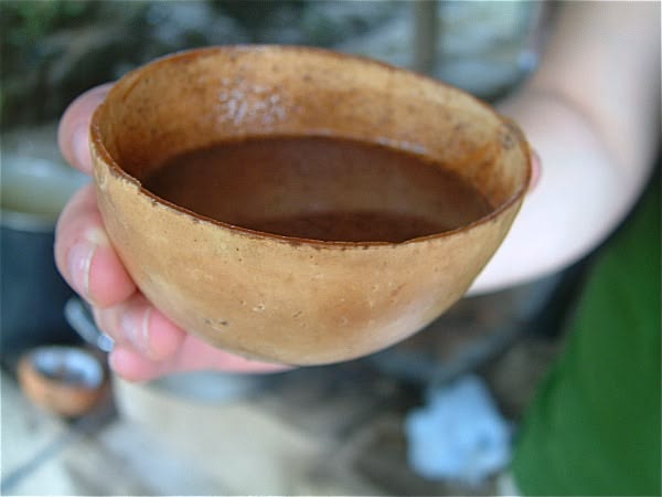 Herbal tea served in rustic cups under tree shade